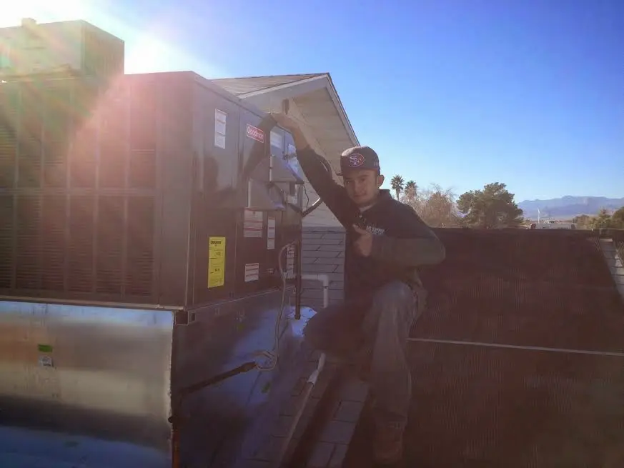 HVAC technician performing Air Duct Cleaning on a rooftop unit in Lower Oxford